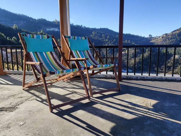 Deck chairs on the sunny terrace facing the valley at Enchanted Hills